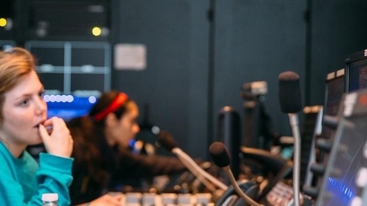 Three female students work the communications console at Trinity's newsroom, TigerTV