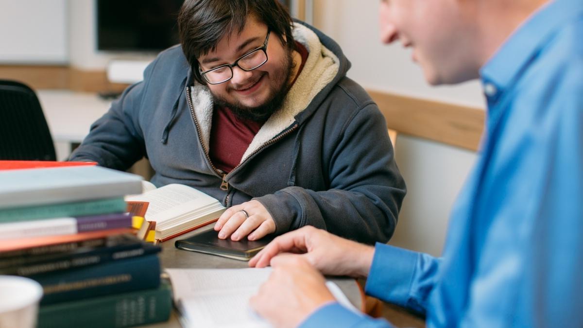 Student and professor discussing a book