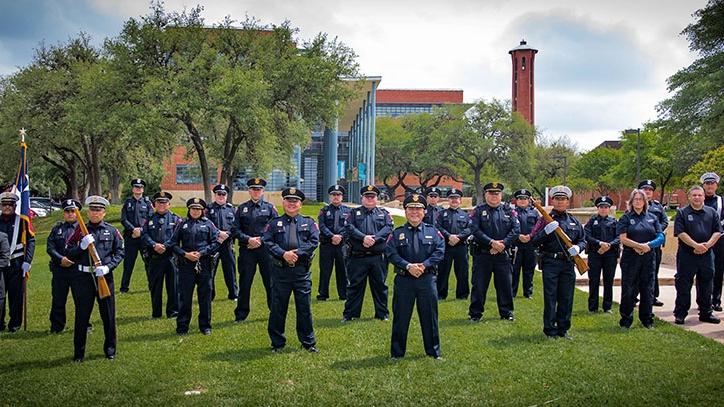 Trinity police department in uniforms on front lawn of campus